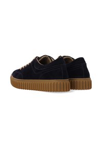 Marineblauwe suède schoenen met een gestructureerde bovenkant, voorzien van een bruine rubberen zool en beige veters, ontworpen voor casual gebruik.
