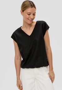 Zwarte linnen top met een V-hals, korte mouwen en een relaxed fit. Heeft een gladde textuur en een eenvoudig ontwerp, geschikt voor casual gebruik.