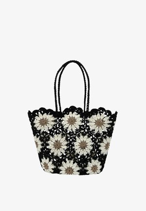 Sac cabas en crochet noir avec motifs de marguerites blanches et beiges et deux poignées tressées, design à tissage ouvert.
