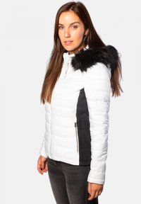 Blouson blanc en duvet avec des panneaux latéraux en velours côtelé noir, fermeture éclair à l'avant et capuche avec fourrure. Texture lisse avec un motif matelassé.