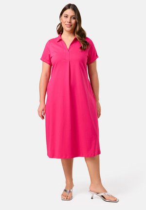 Rosa Midi-Kleid mit kurzen Ärmeln, Kragen und V-Ausschnitt, aus leichtem Material gefertigt. Kombiniert mit silbernen Absatzsandalen.
