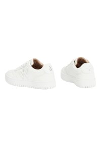 Baskets blanches avec une tige en cuir lisse, bout rond, lacets plats et semelle en caoutchouc texturée, avec des accents logo discrets sur le talon.