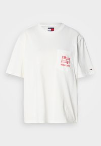 Camiseta blanca de algodón con un corte relajado, con un estampado gráfico rojo en el bolsillo izquierdo del pecho y el logo de Tommy Jeans en la manga.