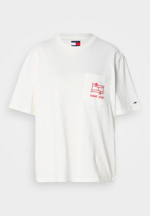 Fehér pamut póló laza fazonnal, bal mellzsebén piros grafikával, és a Tommy Jeans logóval az ujján.