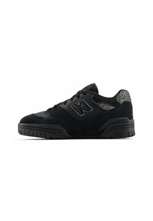 Black low-top sneaker with textured sole, lace-up design, suede panels, and patterned accents on heel and side logo.