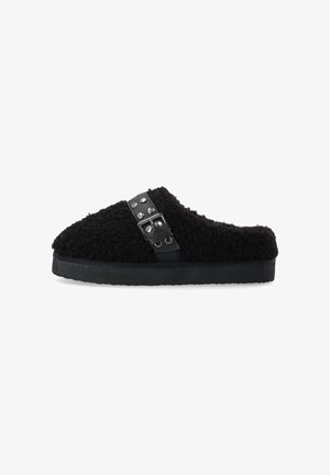 Schwarze, fuzzy Hausschuhe mit einer strukturierten Oberseite und einer flachen, schwarzen Gummisohle. Mit einem schwarzen Riemen mit metallischen Nieten für Details.