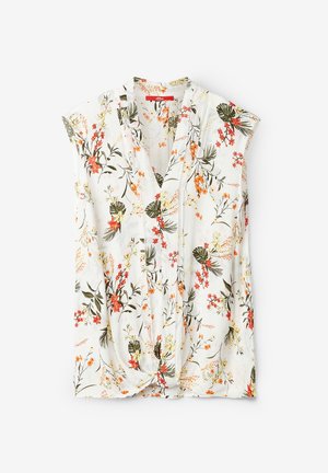 Bluse med blomsterprint i letvægtsstof, der har en hvid baggrund med orange, røde og grønne blomster. Korte ærmer og en knyttet kant.