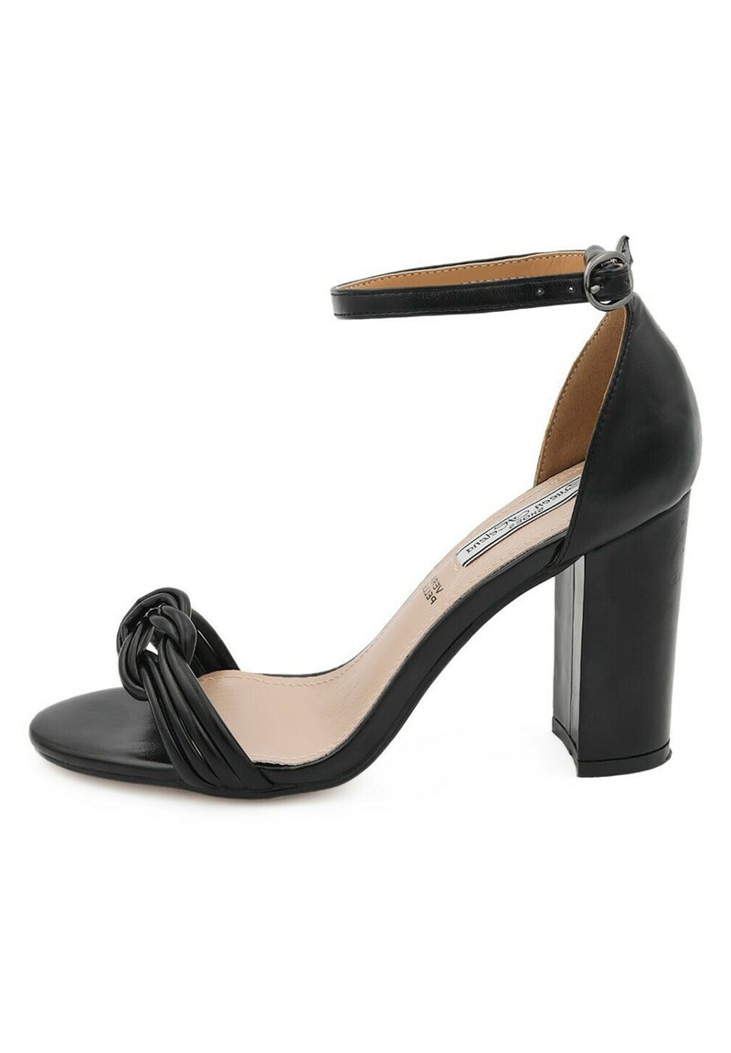 Sandalo nero con tacco alto, design anteriore annodato, punta aperta, cinturino alla caviglia regolabile e tacco spesso. Finitura in pelle liscia.