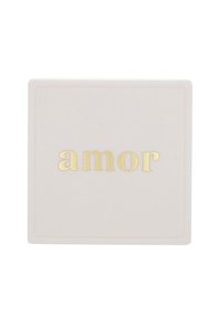 Contenitore quadrato compatto realizzato in materiale rosa pallido con lettering dorato a rilievo che scrive "amor". Texture liscia con un sottile design a bordo.