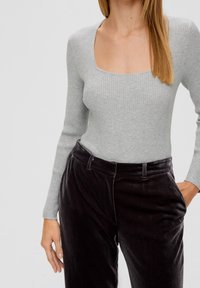Gray ribbed long-sleeve bodysuit with a square neckline, paired with high-waisted black corduroy pants featuring side pockets.