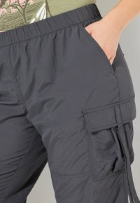 Zwarte lichtgewicht cargo pants met een elastische tailleband, zijzakken en een gemêleerde stof. Geschikt voor casual en buitengebruik.