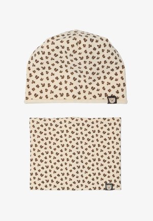 Beiges Baby-Hut- und Halswärmer-Set mit dunkelbraunen und schwarzen Leopardenflecken und einem kleinen Aufnäher mit Löwengesicht auf jedem Artikel.