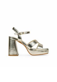 Metallisch goldene Plateausandalen mit breiten Absätzen, die gekreuzte Riemen und einen verstellbaren Knöchelriemen aufweisen. Glatte Textur mit glänzender Oberfläche.