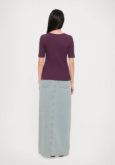Purple short-sleeved top paired with a light blue, floor-length denim skirt. The skirt has a straight cut and two back pockets.