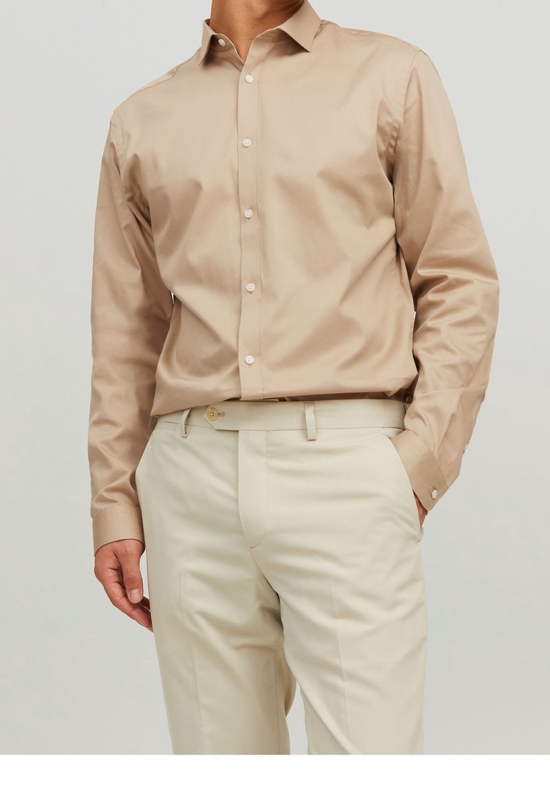 Beige overhemd met knopen, voorzien van een klassieke kraag, lange mouwen en een gladde textuur, gecombineerd met lichtgekleurde, op maat gemaakte broek.