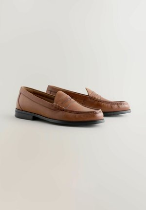 Brune læder loafers med rundet tå, med synlige stikninger og en let hæl. Sort gummisål giver godt greb og holdbarhed.