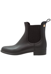 Bottes Chelsea en caoutchouc noir avec des panneaux élastiques sur les côtés et un petit emblème doré. Talon bloc bas et texture lisse et brillante.