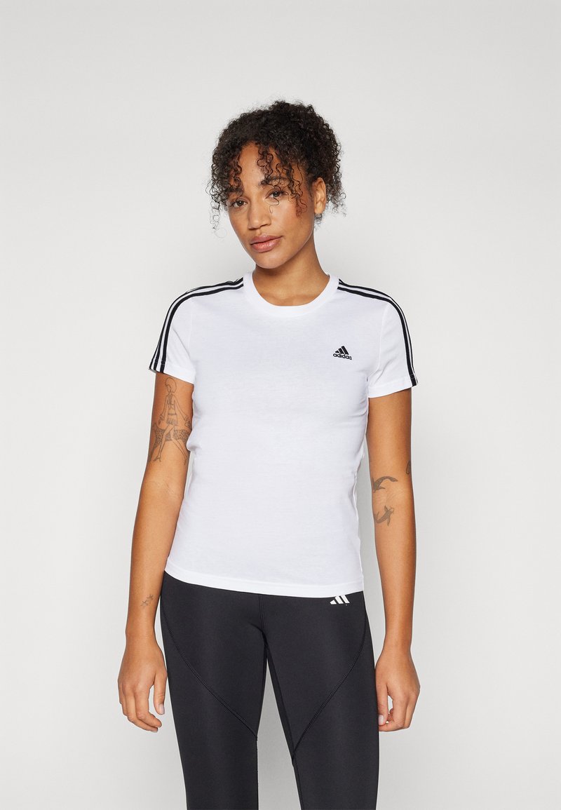 Bela kratka majica s kratkimi rokavi, črne črte na ramenih in majhnim črnim adidas logotipom na levem prsnem delu. Mehak, prilegajoč se dizajn.