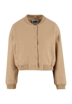 Gilet en beige cropped en tissu doux, avec un col rond, des boutons-pression et deux poches latérales, avec des poignets et un bas côtelés.