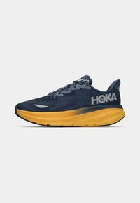Running shoe featuring a navy upper with textured mesh, a yellow cushioned sole, and reflective accents. Laced design with logo displayed.