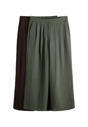 Deux paires de pantalons larges courts, un vert olive à l'avant et un marron foncé partiellement visible derrière, tous deux avec des ceintures élastiques.