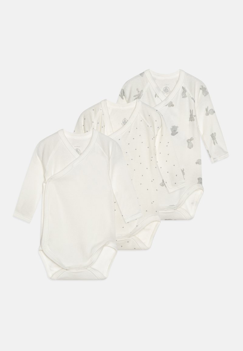 Trois bodys en jersey à manches longues pour bébé en doux tissu blanc. Un uni, un à pois et un avec des imprimés de lapins gris. Tous présentent un design enveloppant.