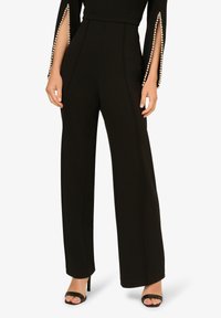 Černé kalhoty širokého střihu s hladkým povrchem, s perlovými detaily na manžetách a přiléhajícím pasem pro elegantní vzhled.