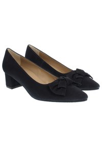 Schwarze Wildleder-Pumps mit einem niedrigen Blockabsatz, spitzem Zehenbereich und einem dekorativen Schleifenakzent an der Vorderseite. Die Innenseite ist mit einem glatten beigen Futter ausgestattet.