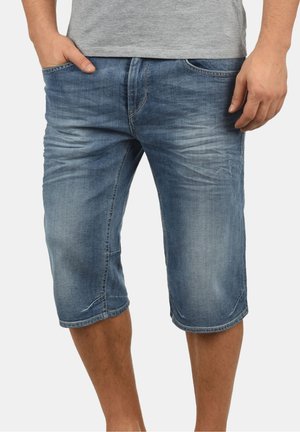 Jeans-Shorts in hellblau bis dunkelblauem Waschung, knielang mit fünf Taschen, Ausbleichungsdetails und gestickten Akzenten entlang der Nähte.