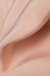Růžová saténová tkanina s hladkou texturou, vykazující jemné záhyby a mírný lesk. Materiál je lehký a elegantně splývá.
