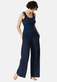Marineblauw tanktop en brede broek, beide gemaakt van zachte stof. De tanktop heeft een ronde halslijn en de broek heeft zijzakken.
