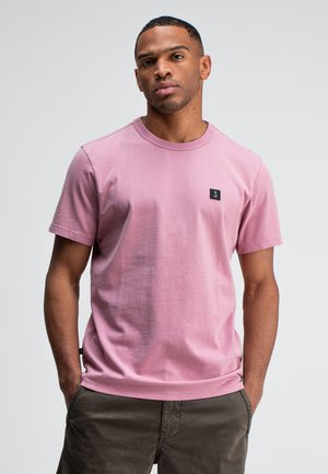 Roze katoenen t-shirt met korte mouwen, ronde halslijn en een klein zwart logo op de linkerborst. Soepele textuur, casual pasvorm.