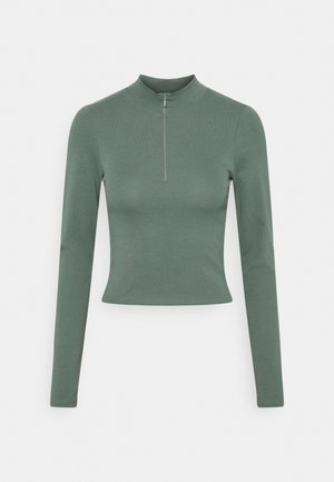 Langetermijn mouwen, cropped top in gedempt groen, gemaakt van gladde, rekbare stof met een hoge nek en een ritsdetail aan de voorkant.