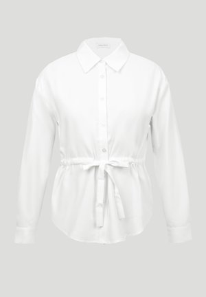 Λευκό πουκάμισο με μακριά μανίκια, κουμπιά, μυτερό γιακά και ζώνη στη μέση, παρουσιάζεται σε ανοιχτό γκρι φόντο.