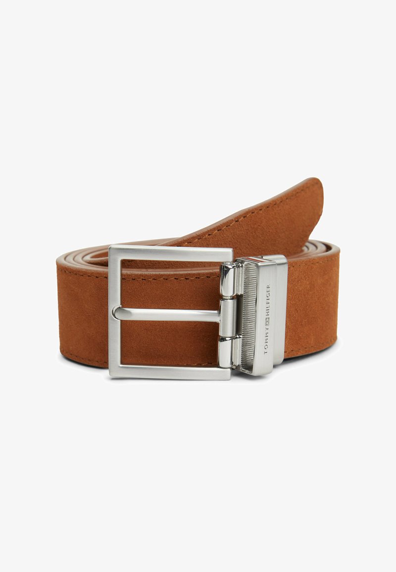 Brown suede leather belt rolled up with a silver rectangular metal buckle engraved with "Tommy Hilfiger" on a white background.