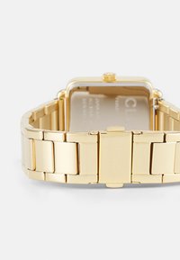 Gold-toned wristwatch with a rectangular case, metal bracelet, and textured links. Features a crown for adjustment, polished finish.
