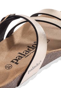 Sandal Palado con cinturini metallici argento, plantare in sughero marrone testurizzato e suola in gomma bianca con logo impresso.
