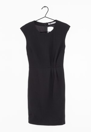 Černé bezrukávové šaty s kulatým výstřihem, švem v pase a jemnými sklady vpředu; vyrobené z hladké látky. Visí na černém háčku.