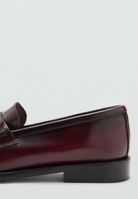 Bordowy, skórzany mokasyn z zaokrąglonym noskiem, minimalnym przeszyciem i niskim czarnym obcasem. Gładka faktura z polerowanym wykończeniem.