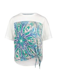 Hvid t-shirt med et blåt og grønt abstrakt print på forsiden, og en knude-detalje i bunden til venstre side. Korte ærmer.