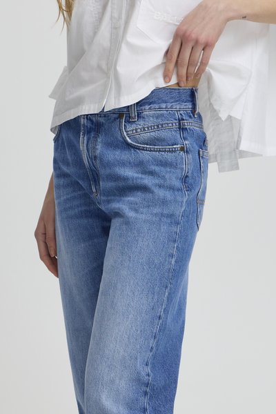 Jeans din denim de o nuanță deschisă, cu o croială clasică dreaptă, având cinci buzunare, accesorii din alamă și uzură subtilă pe coapse.