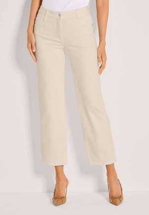 Beige, wijde broek van zachte stof met steekzakken aan de voorkant, een knoopsluiting en een gladde textuur, gecombineerd met nude hakken.