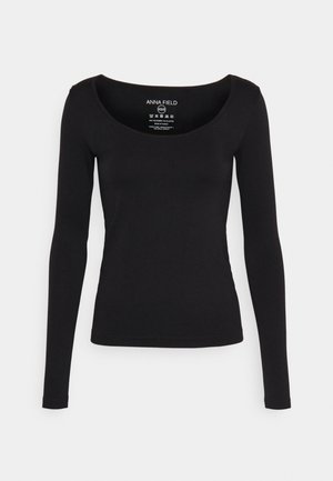 Black long-sleeve top with a scoop neckline, made of a smooth, stretchy fabric. Features a label with brand and care instructions inside.