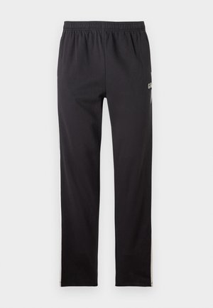 Schwarze Sporthose aus weichem Baumwollmix, mit einem elastischen Bund und seitlichen Streifen, sowie einem kleinen Logo am linken Bein.