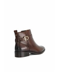 Bruine leren enkelboots met een ronde neus, lage blokhak en een gouden gespaccent aan de zijkant. Gladde textuur en gestikt ontwerp.
