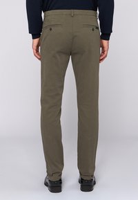 Kaki-byxor med slim fit, smidigt bomullstyg, två bakfickor med knappstängning och något smalnande ben.