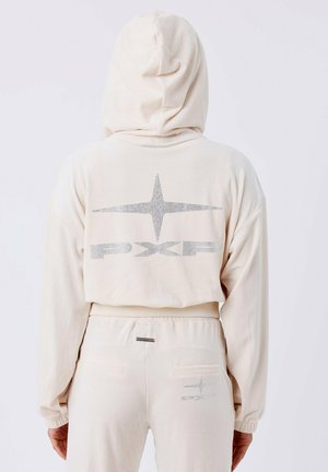 Sudadera color crema con capucha y puños acanalados. Presenta un logotipo brillante y un diseño de estrellas en la parte posterior. Tejido suave con un ajuste holgado.