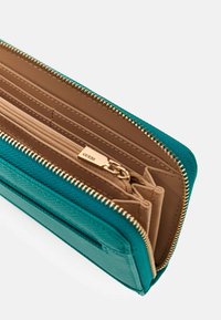 Teal textured wallet with a gold zipper, featuring a beige interior with card slots and a zippered coin pocket.