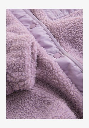 Lila obleka iz flisa z mehko, teksturirano površino. Ima sijoč lila material in okrogle pritrdilne gumbe. Topel in mehak dizajn.