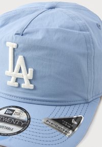 Svijetloplava kapa s izvezenim bijelim "LA" logom. Dizajn uključuje zakrivljeni vizir i podesivu traku s detaljima šivanja.